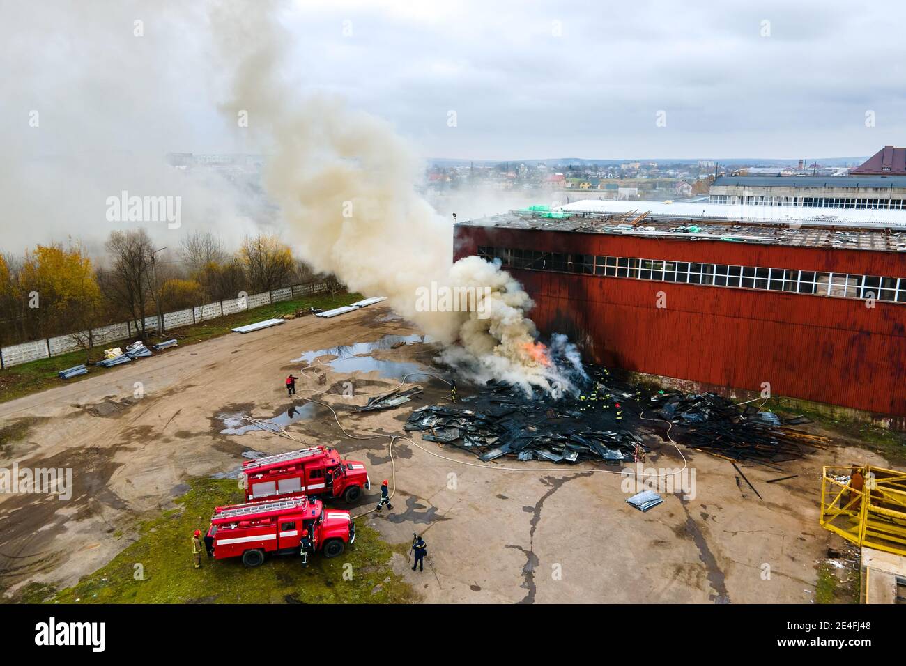 Aerial view of firefighters extinguishing fire in industrial area Stock ...