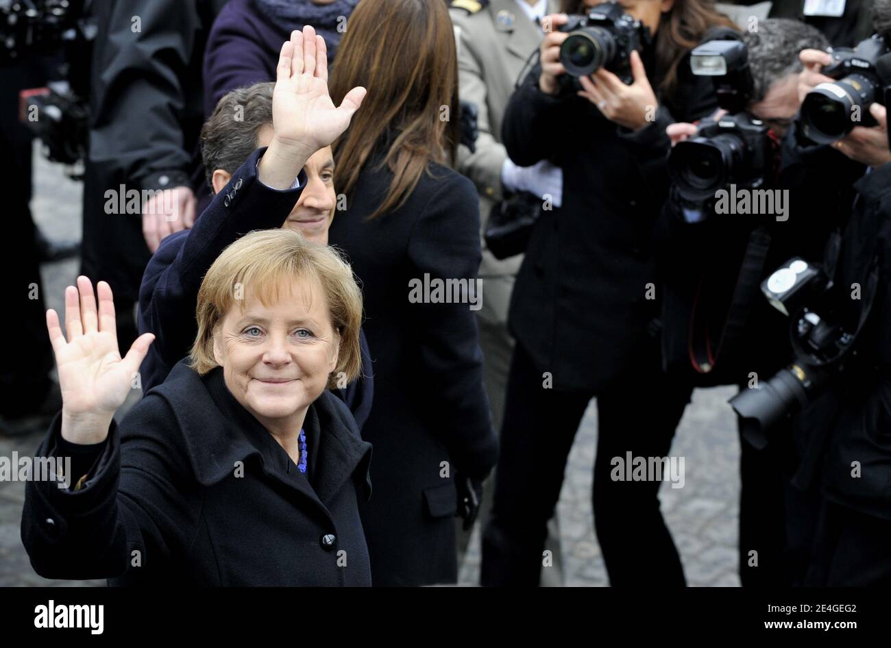 French President Nicolas Sarkozy (R) and German Chancellor Angela Merkel (C) wave to the crowd as they leave the Arc de Triomphe in Paris, on November 11, 2009 after an Armistice Day ceremony, marking the 91th anniversary of the end of World War I. Photo by Christophe Guibbaud/ABACAPRESS.COM Stock Photo