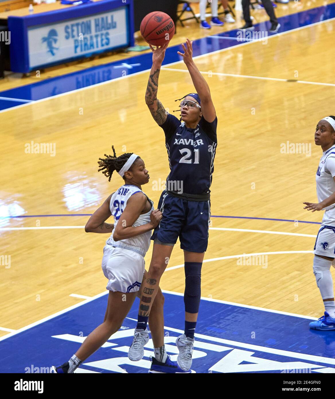 January 23, 2021, South Orange, New Jersey, USA: Xavier Musketeers forward A'Riana Gray (21) shoots over Seton Hall Pirates guard Desiree Elmore (25) in the second half at Walsh Gymnasium in South Orange, New Jersey. Seton Hall defeated Xavier 85-59. Duncan Williams/(Photo by Duncan Williams/CSM/Sipa USA) Stock Photo