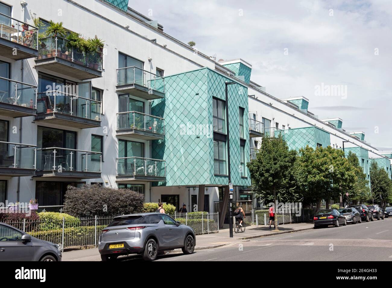Flats or appartments with turquoise architectural patina copper cladding, with people passing Drayton Park Highbury London Borough of Islington Stock Photo