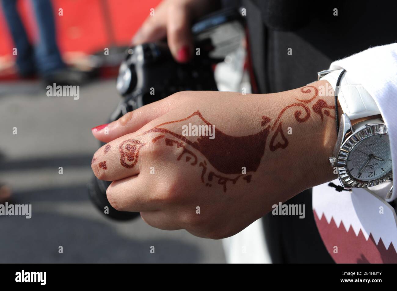 Qatar flag is drawn with henna (temporary tattoo) on a young woman's