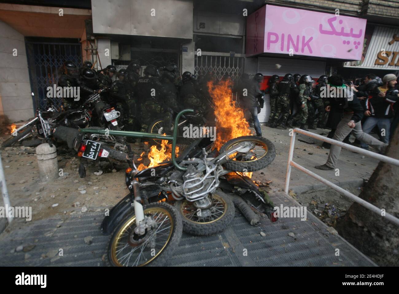 Anti-government protesters and security forces clashed heavily in Tehran, Iran, on December 27, 2009. Police motorcycles burn as an Iranian opposition protester aims a stone at security forces during clashes. Security forces shot dead four protesters in Tehran in a crackdown on vast crowds of opposition supporters who turned a Shiite mourning event into a mass protest, a website and witnesses said. Photo by ABACAPRESS.COM Stock Photo