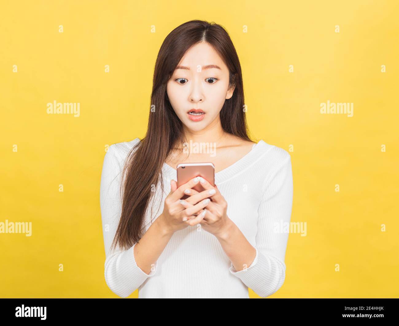 shocked young woman looking at mobile phone Stock Photo