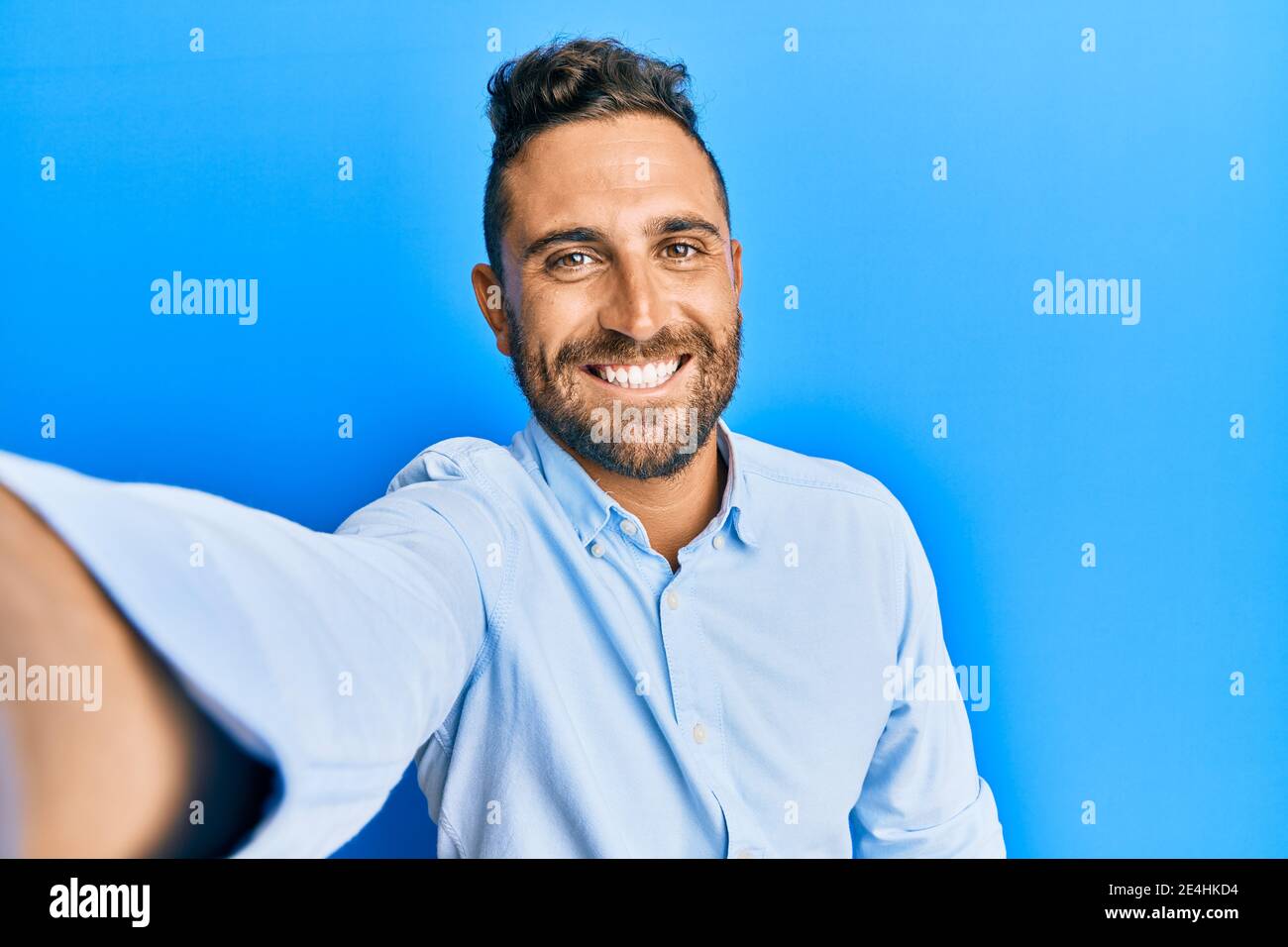 Handsome man with beard taking a selfie photo with smartphone looking ...