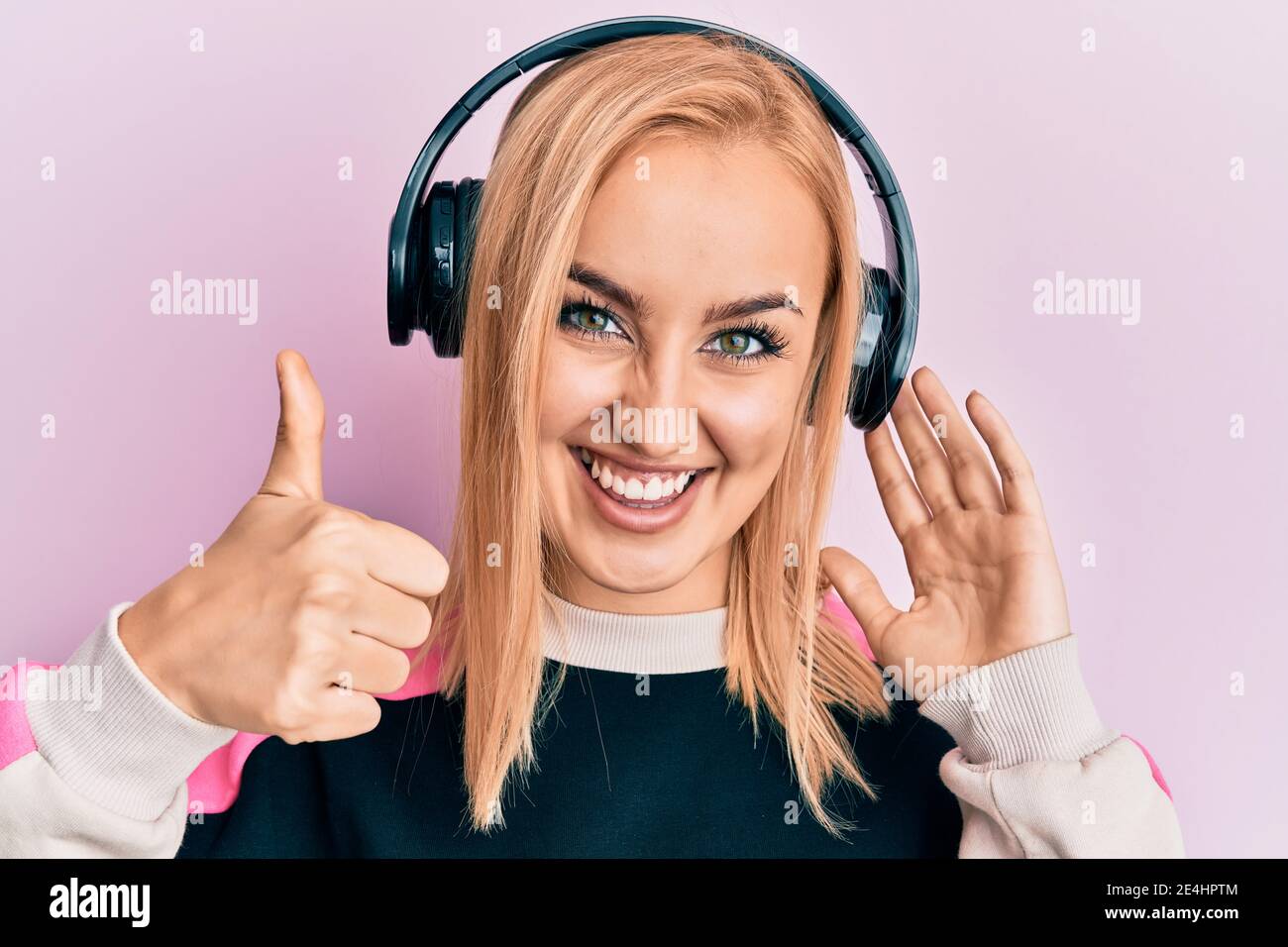 Beautiful caucasian woman listening to music using headphones smiling ...