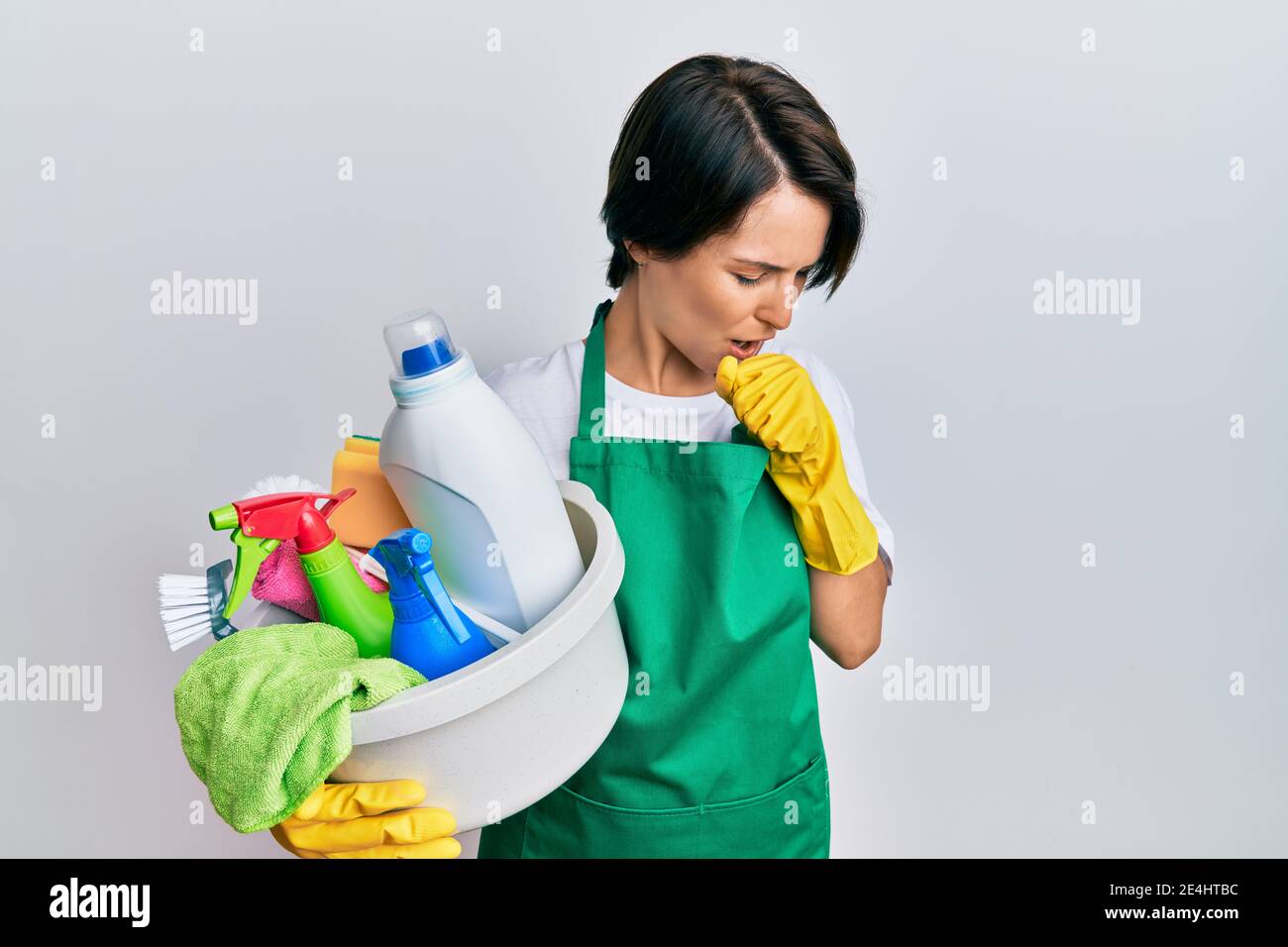 Young woman with short hair wearing apron holding cleaning