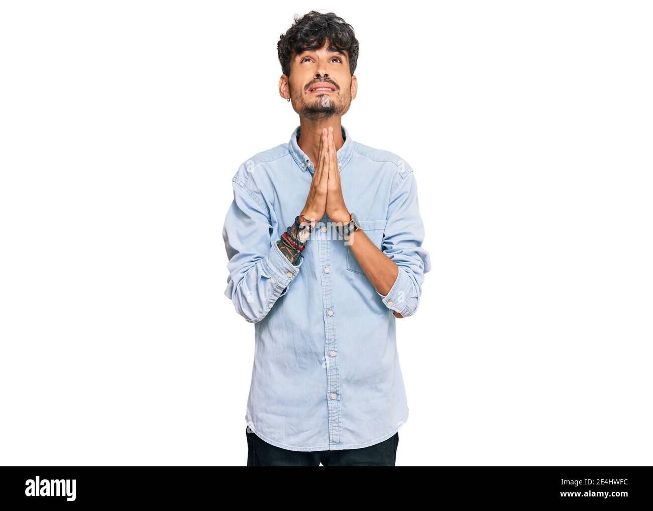 Young hispanic man wearing casual clothes begging and praying with ...