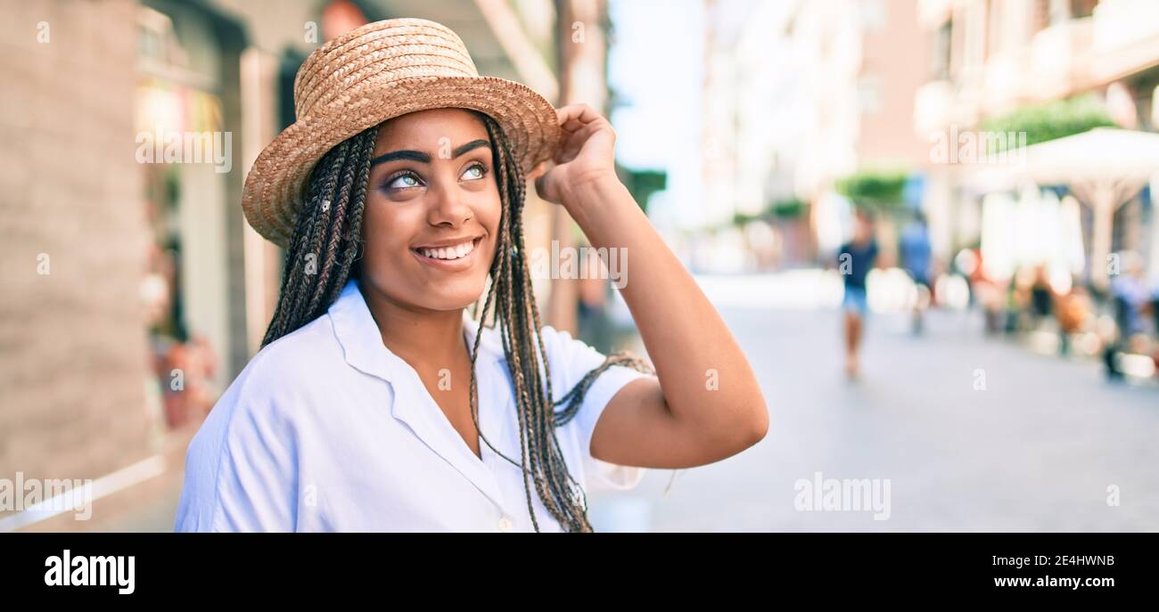 Young african american woman with braids smiling happy outdoors on a ...