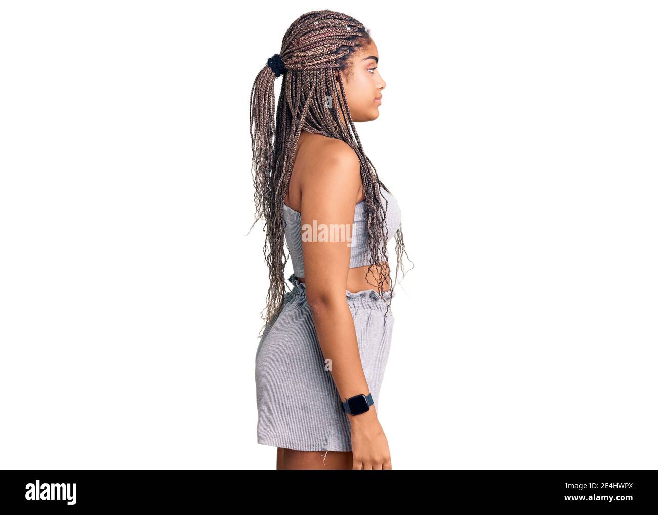 Young african american woman with braids wearing sportswear looking to side, relax profile pose with natural face with confident smile. Stock Photo