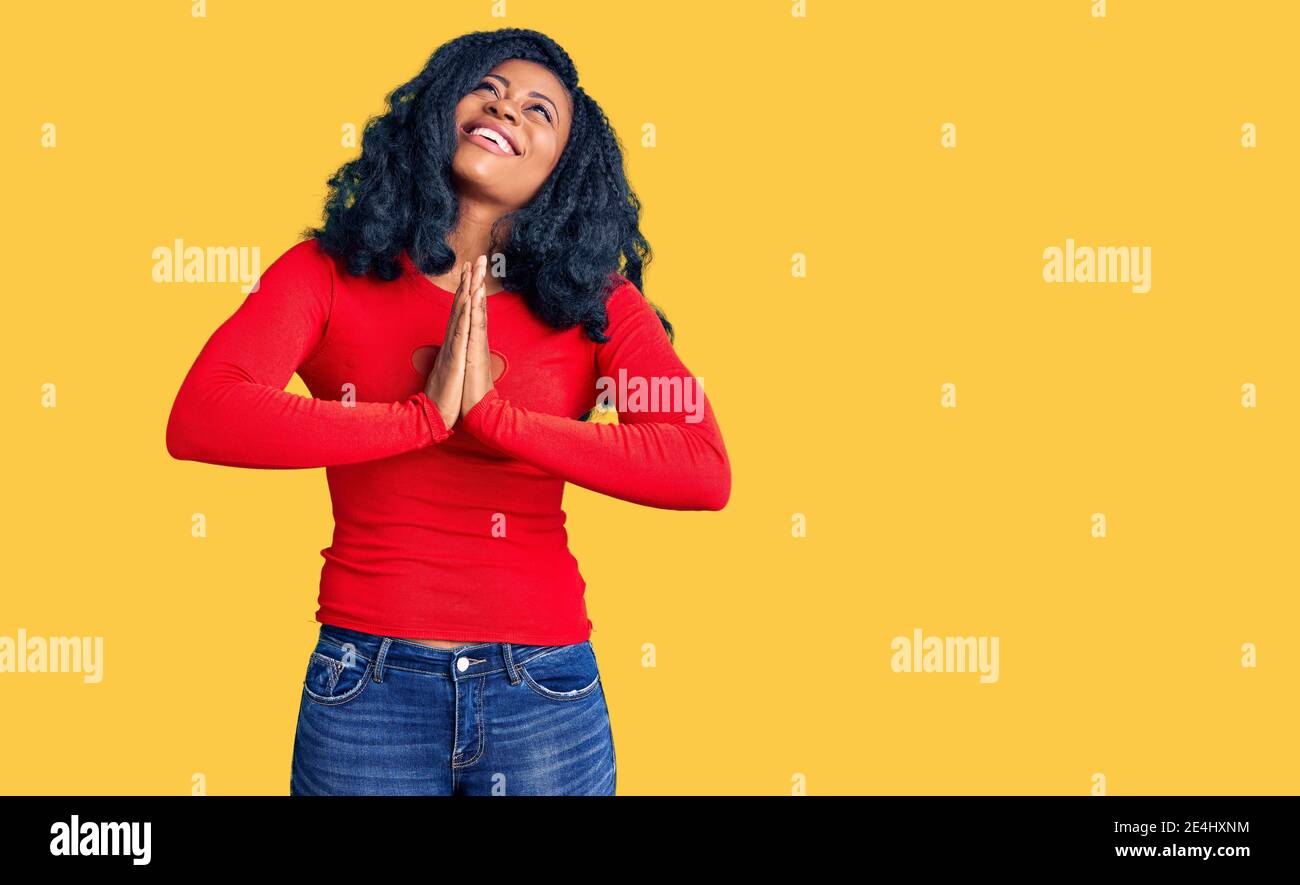 Beautiful african american woman wearing casual clothes begging and praying with hands together with hope expression on face very emotional and worrie Stock Photo
