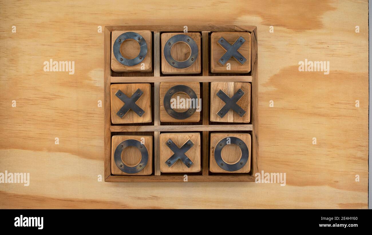 Board game of noughts and crosses on a timber background Stock Photo