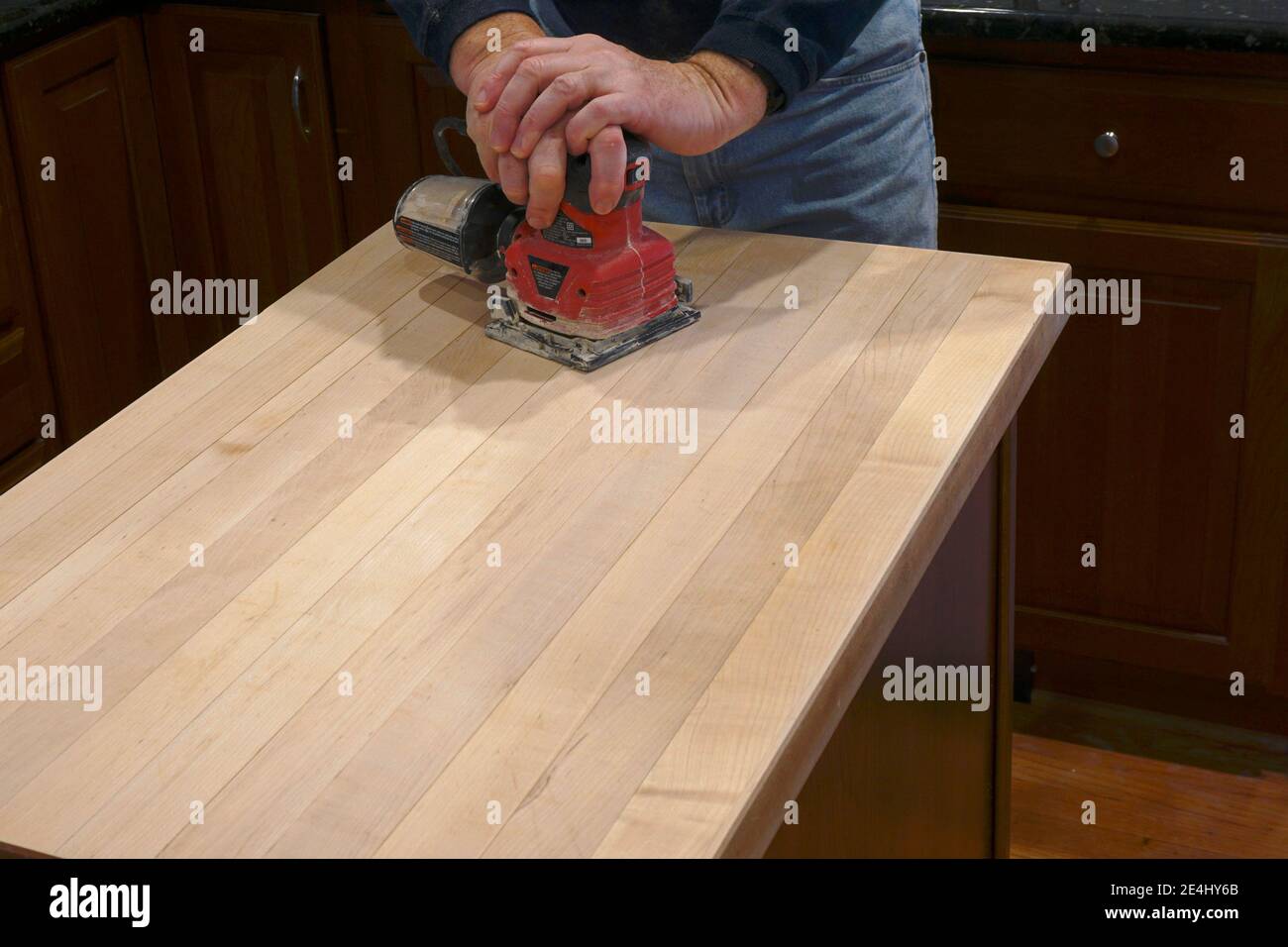 Using an electric sander to refinish a counter top Stock Photo