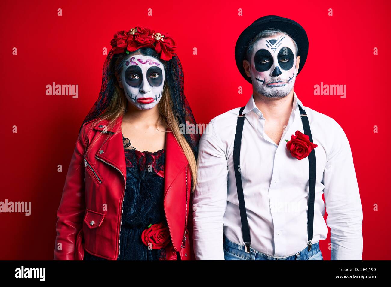 Couple wearing day of the dead costume over red depressed and worry for ...