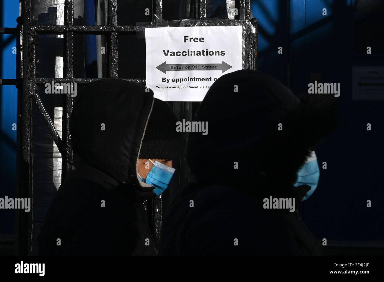 Two people wearing masks walk past a COVID-19 Vaccination Hub in the Elmhurst section of the Queens borough of New York City, NY, January 23, 2021. New York City has ordered 15 if its COVID-19 Vaccinations hubs closed and appointments cancelled due to a shortage of the COVID-19 vaccine; the United States recently surpassed 400,000 deaths due to Coronavirus infections.  (Photo by Anthony Behar/Sipa USA) Stock Photo