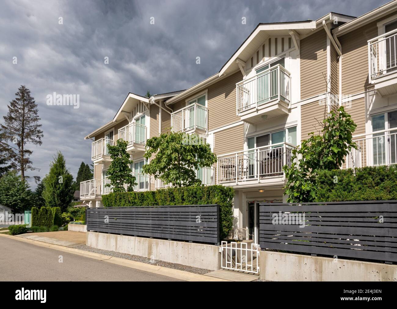Residential condo building with fenced front yard on stormy sky background Stock Photo Alamy