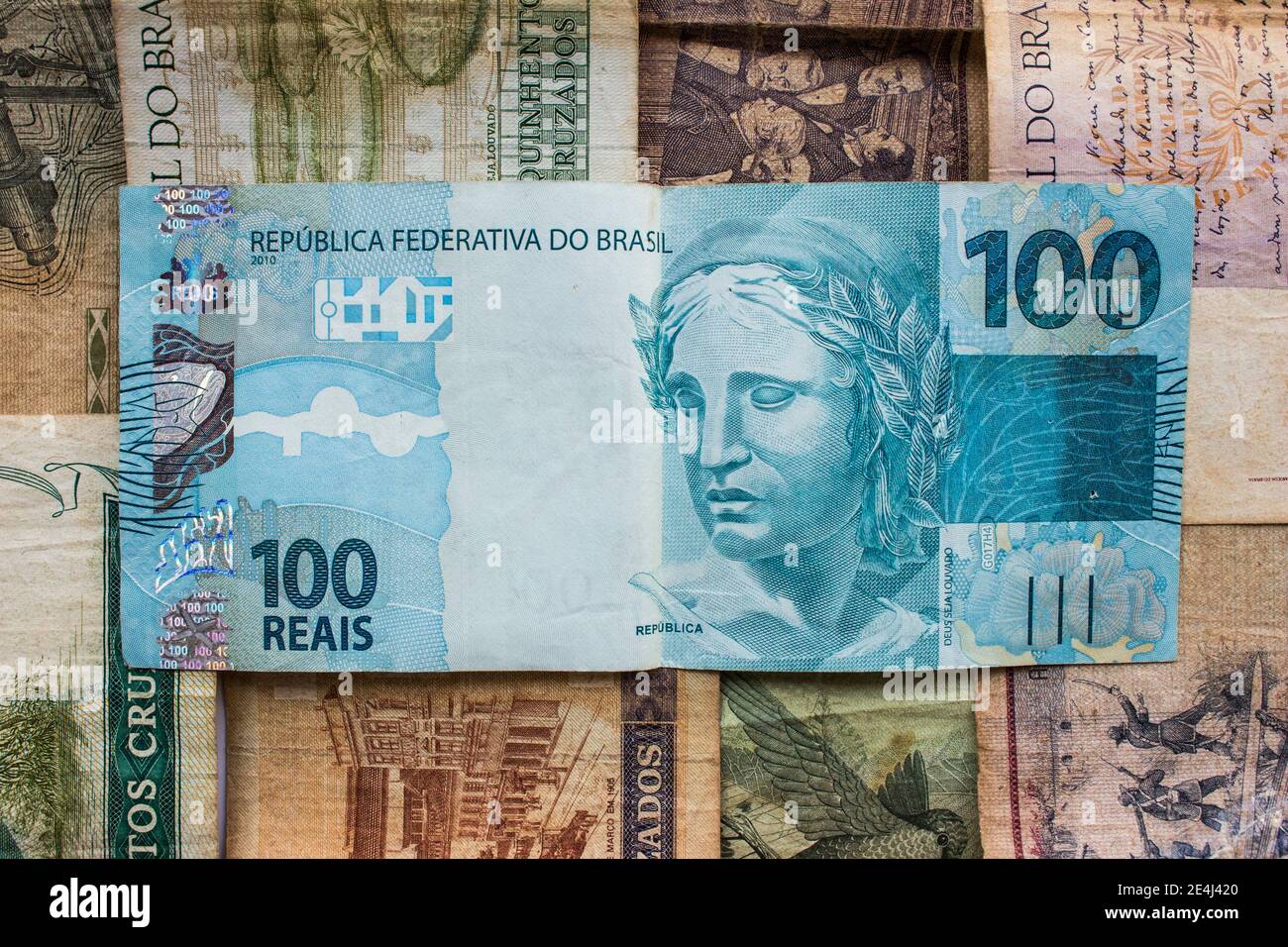 One hundred reais. BTL brazilian blue banknote on top of former national currencies Stock Photo