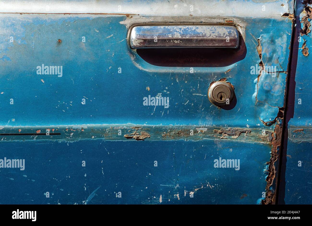 Blue door of a car wreck in Antigua, Guatemala. Focus on keyhole. Stock Photo