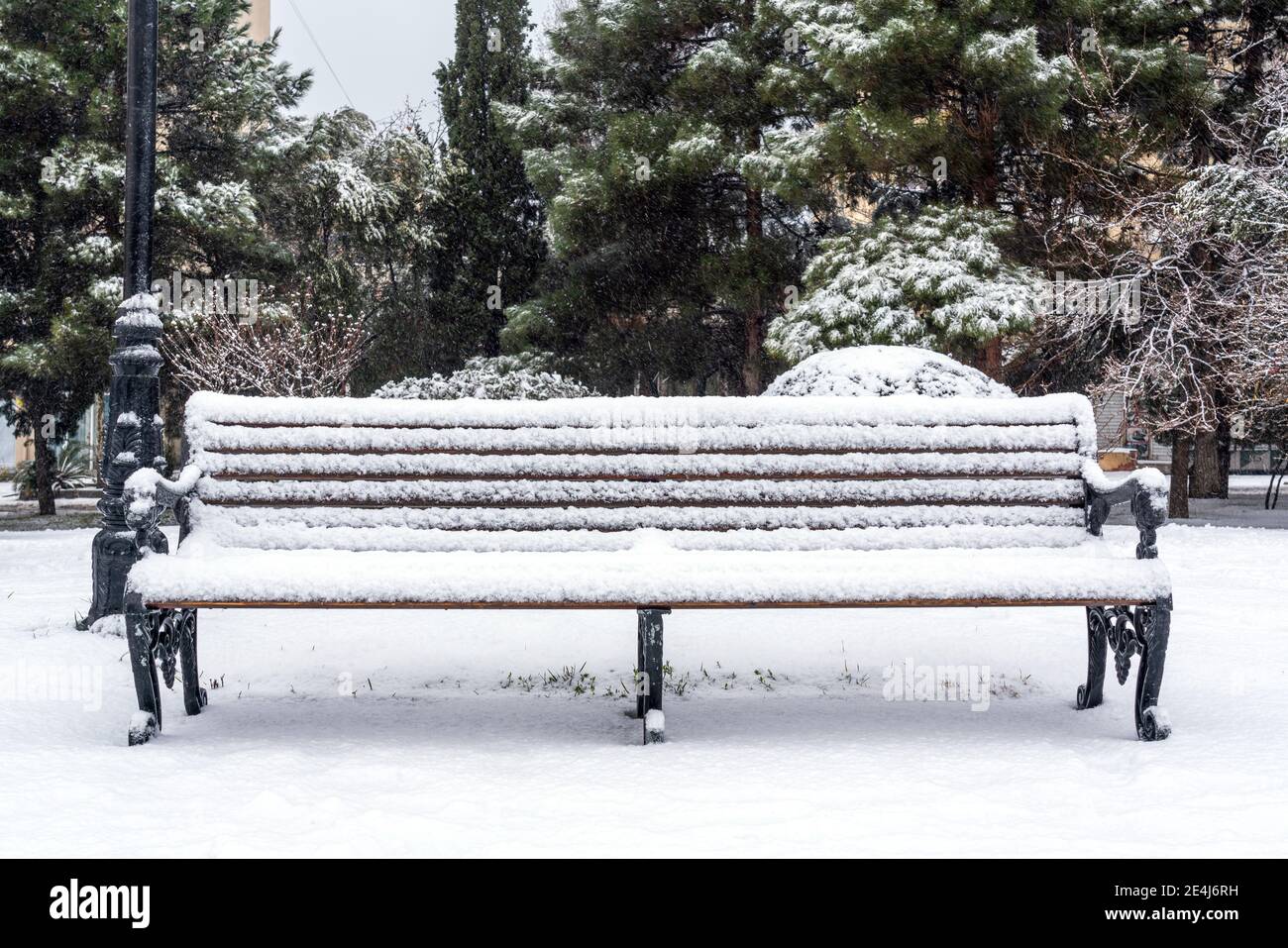 Bench in city park is covered with snow Stock Photo - Alamy