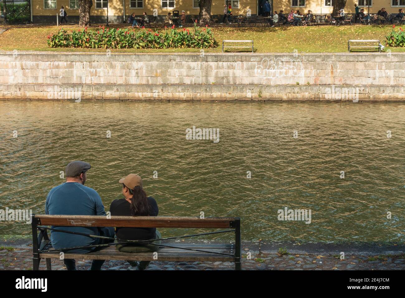 Man and a woman sitting on a park bench hi-res stock photography and ...