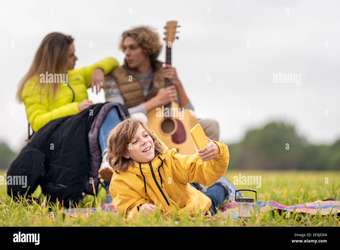 Three siblings camping together on grass Stock Photo