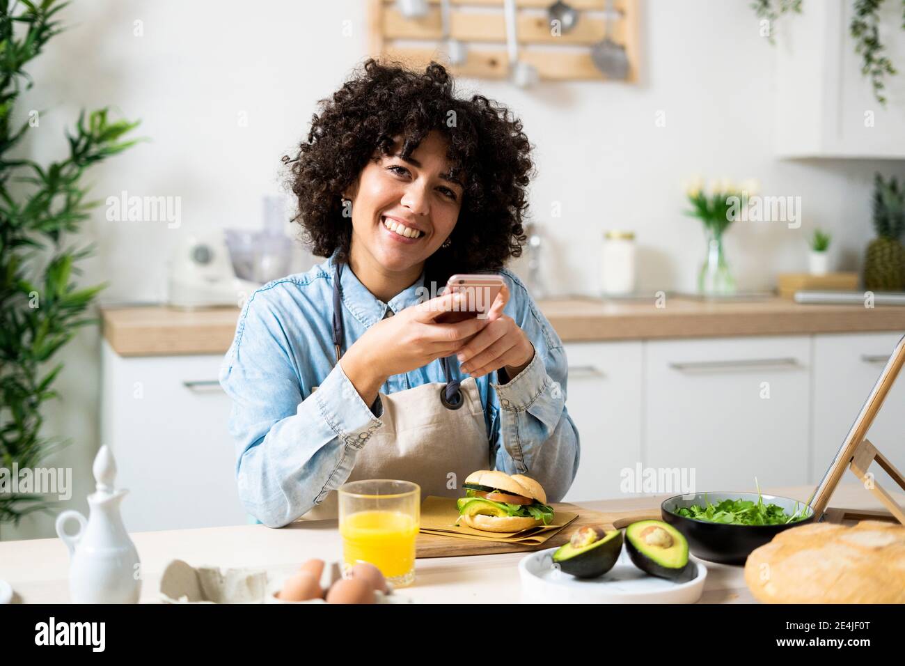 Woman holding smartphone avocado hi-res stock photography and images ...