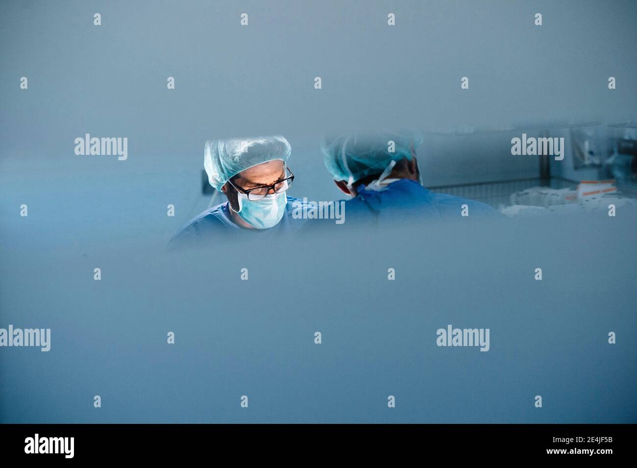 Male orthopedic surgeon with coworker operating surgery in emergency room Stock Photo