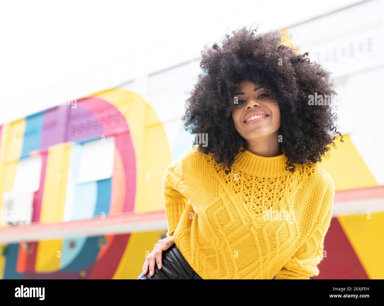 Young woman smiling while standing outdoors Stock Photo