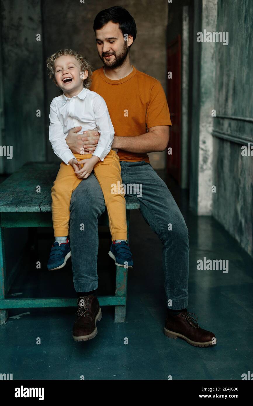Boy sitting on fathers lap hi-res stock photography and images - Alamy