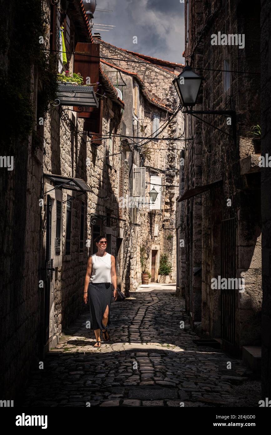 Woman walking narrow old town hi-res stock photography and images - Alamy