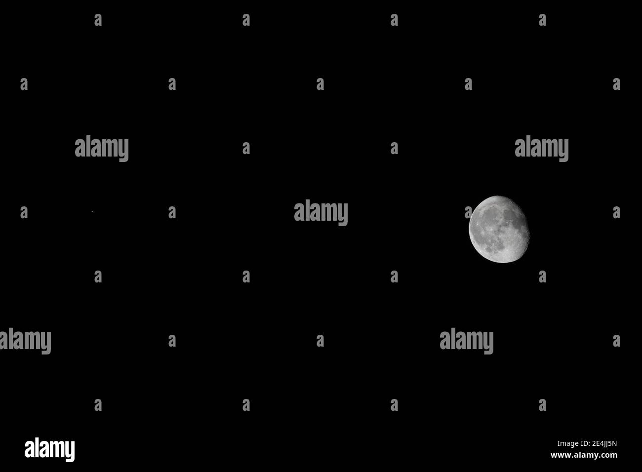 Mars (as a small red dot on the left) next to a waning gibbous moon in scale in one single picture Stock Photo