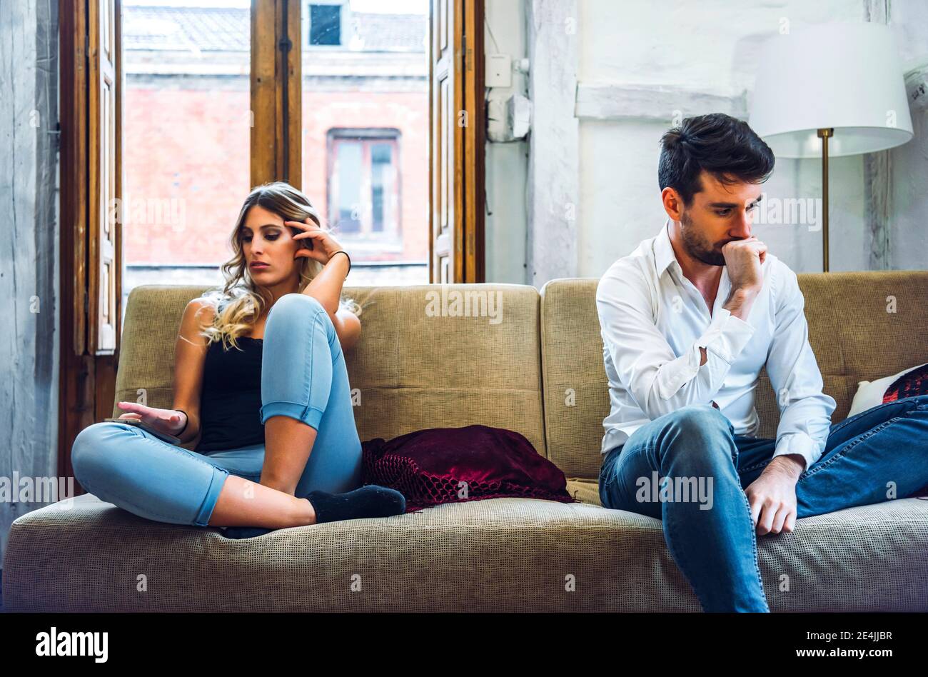 Couple sitting on sofa apart and being angry after quarrel Stock Photo ...