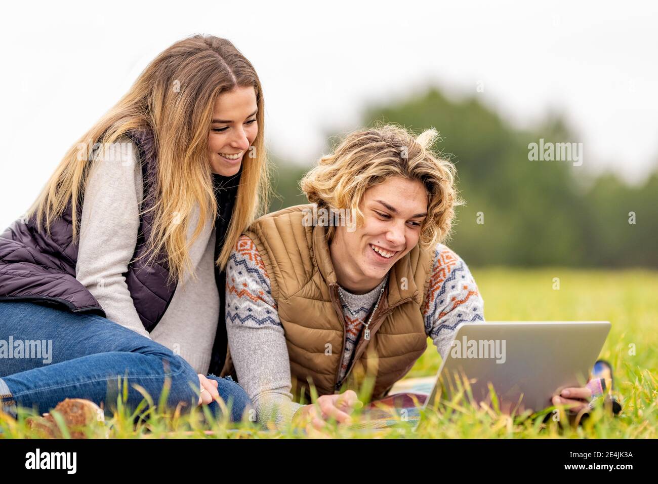 Brother and sister lying together on grass with digital tablet Stock ...
