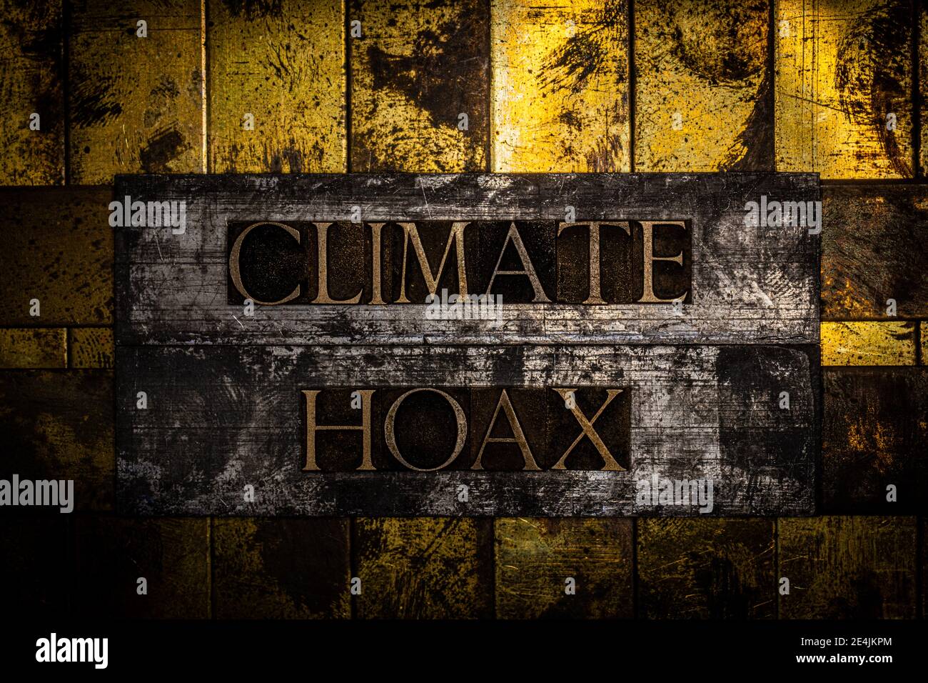 Climate Hoax text on textured lead with grungy copper and gold background Stock Photo
