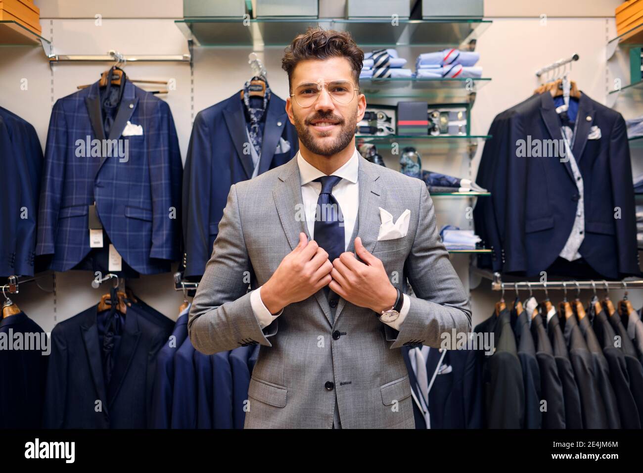 Portrait of smiling man in gray suit in tailors boutique Stock Photo