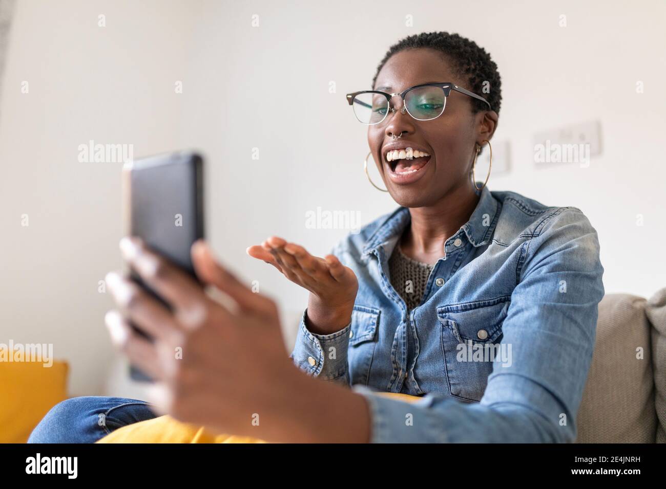 Smiling woman having video call at home Stock Photo