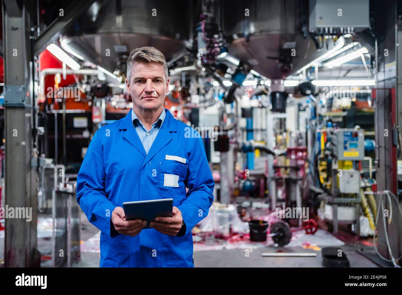 Mature engineer holding digital tablet while standing in industry Stock Photo