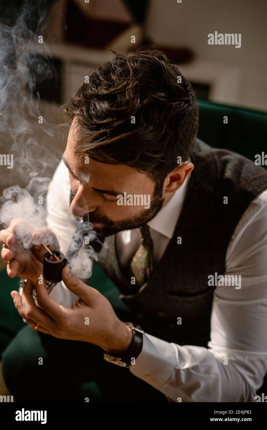 Bearded man smoking pipe Stock Photo