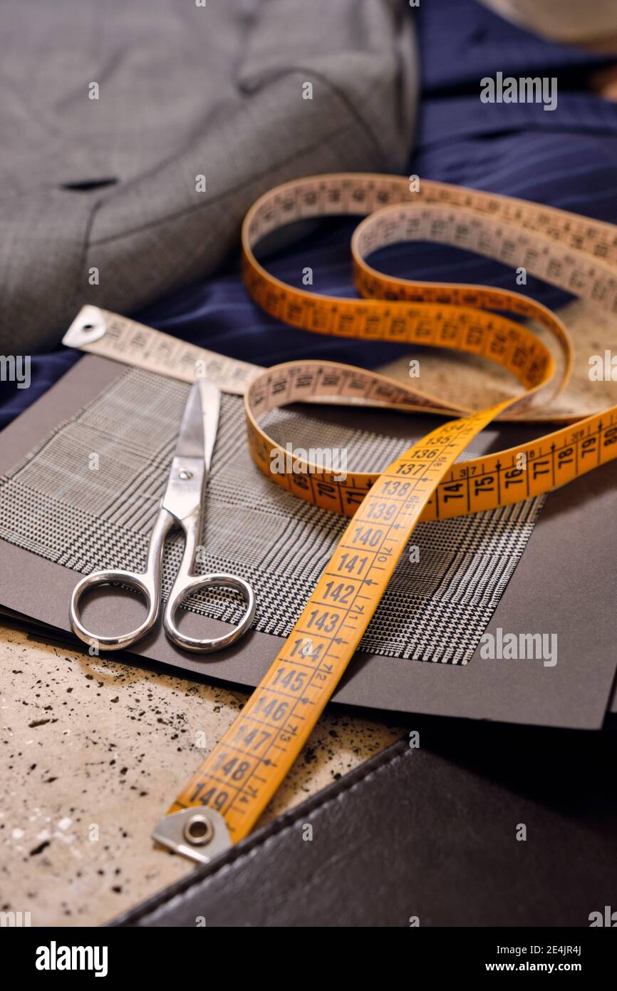 Scissors and tape measure in tailors boutique Stock Photo