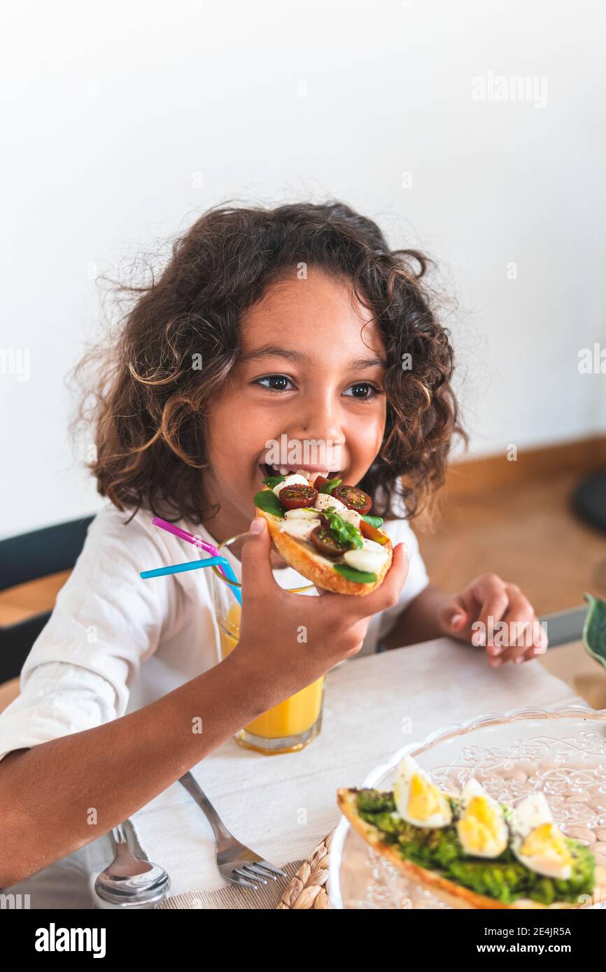 Portrait of little girl eating breakfast Stock Photo