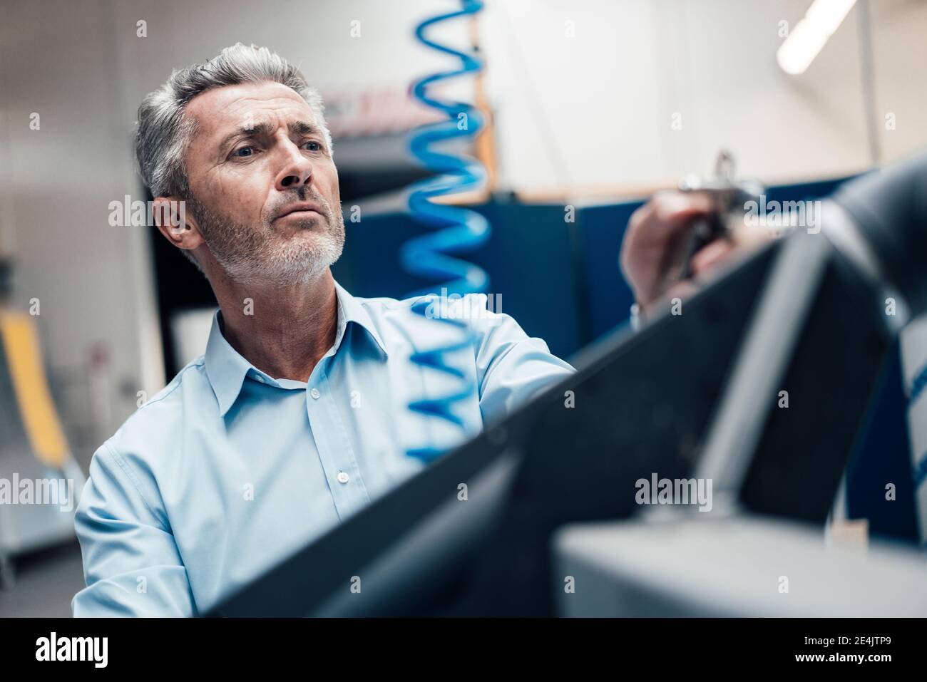 Mature businessman working while standing at industry Stock Photo