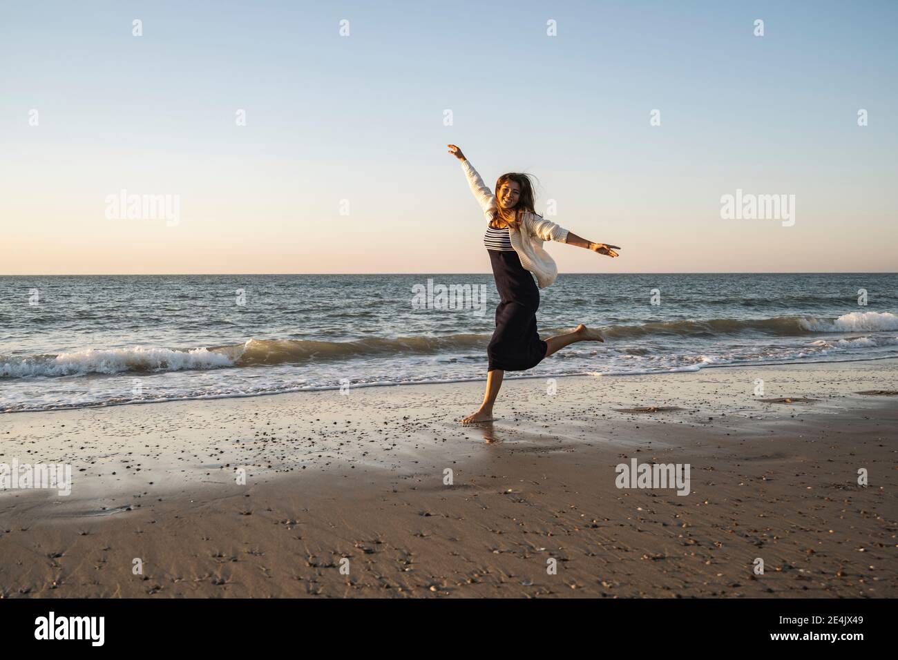 Woman sunset beach carefree hi-res stock photography and images - Alamy