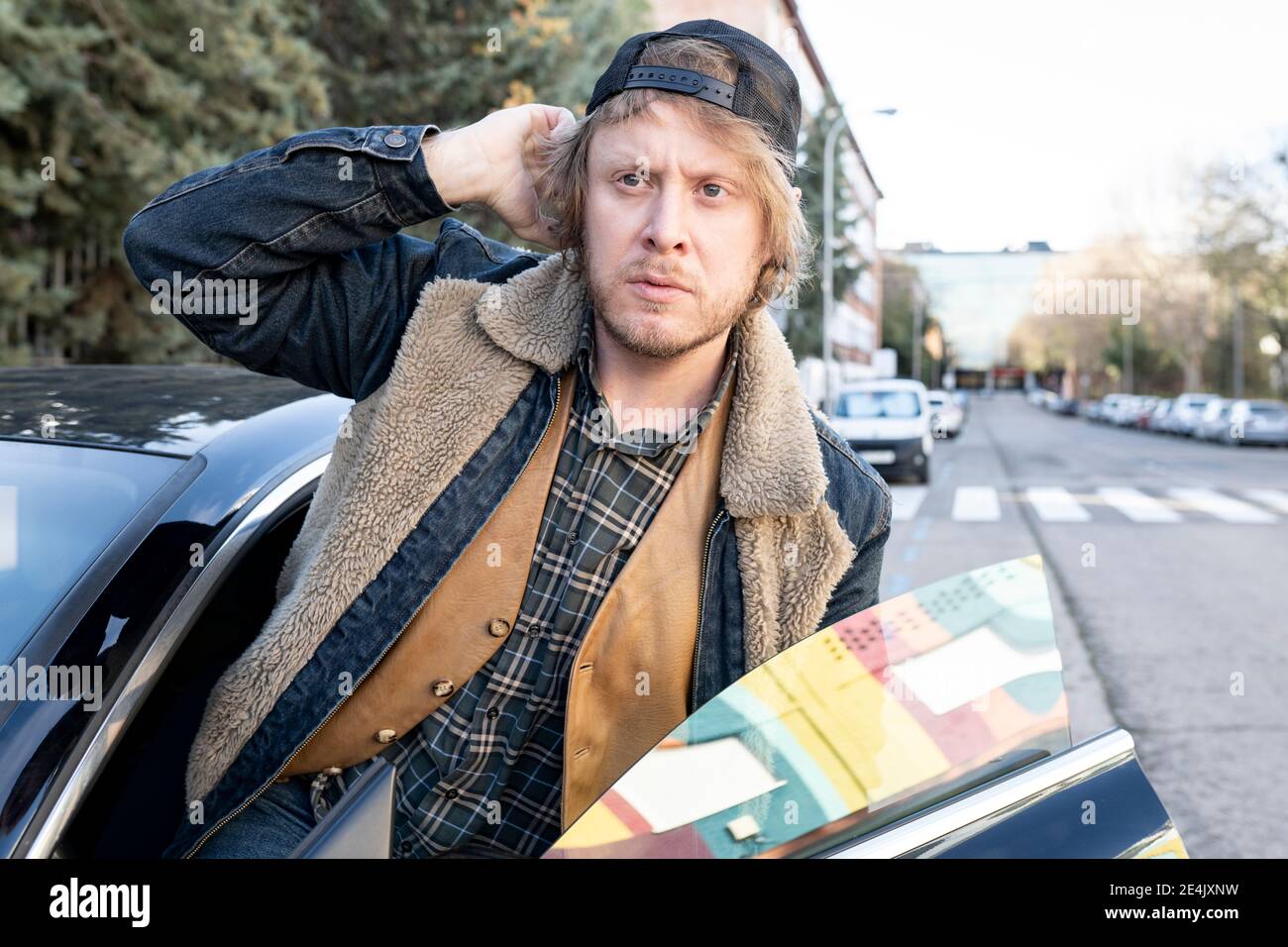 Man looking away while disembarking from car Stock Photo