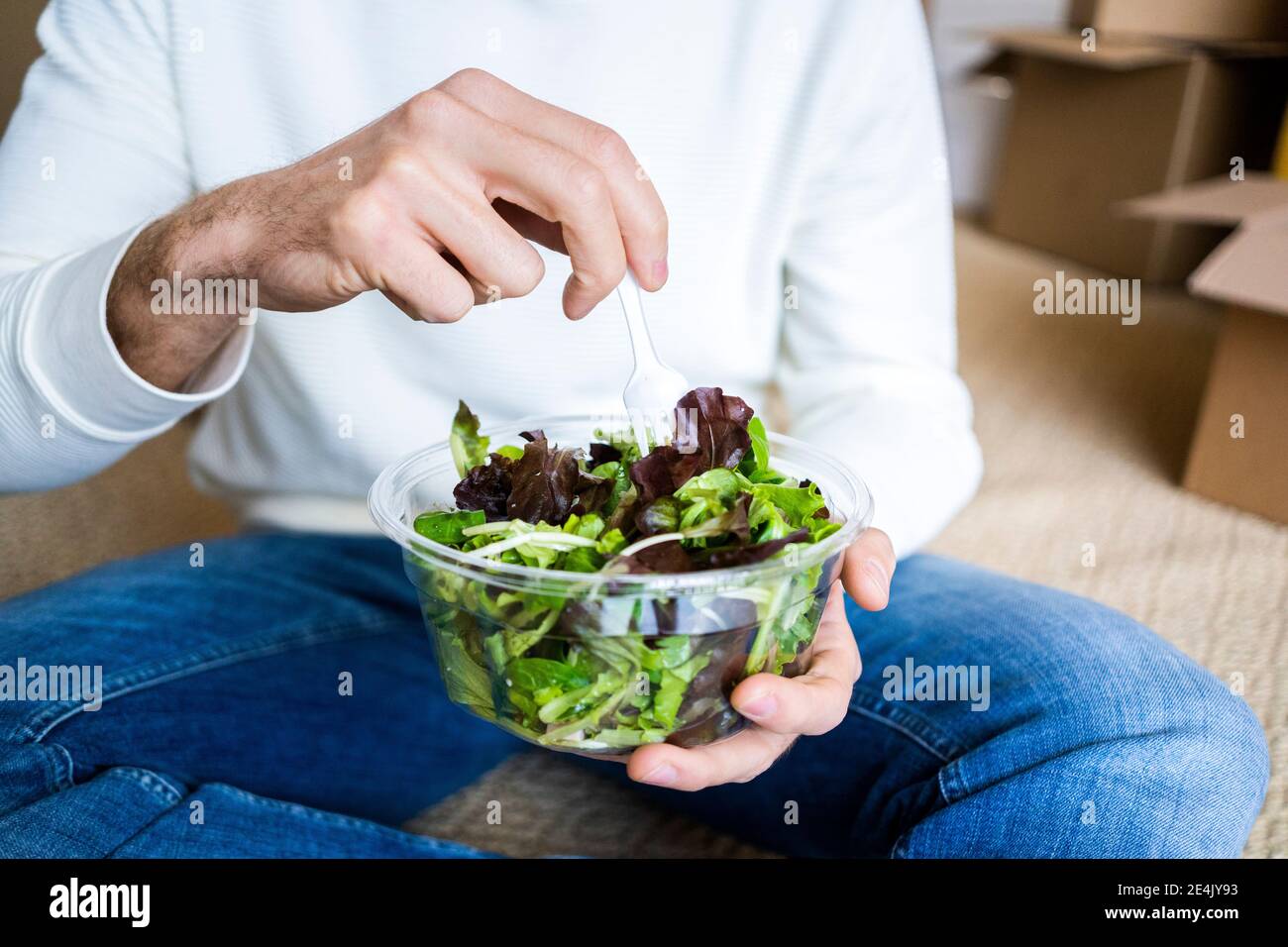 Young woman holding leafy vegetable salad in new home Stock Photo