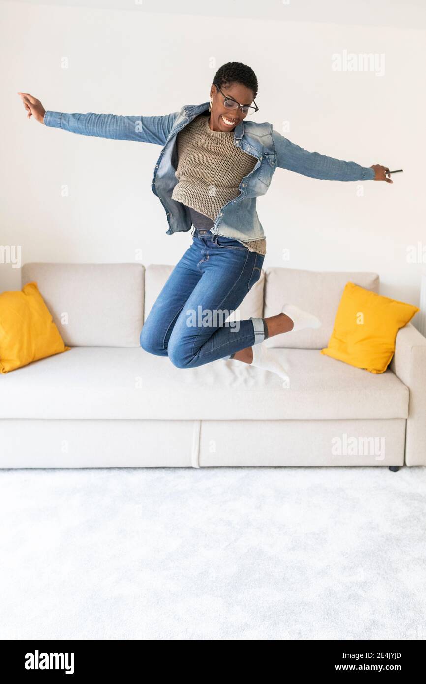 Happy woman jumping sofa hi-res stock photography and images - Alamy