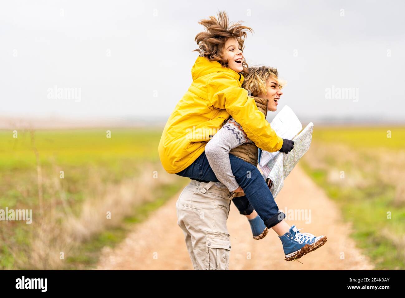 Young man piggybacking younger brother during hike Stock Photo