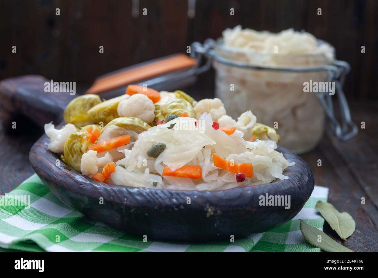 Homemade vegetables and sauerkraut pickling in rustic wooden plate. Healthy probiotic food full of vitamins. Stock Photo
