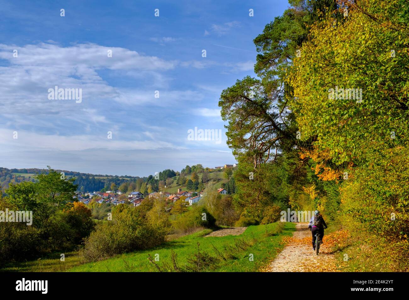 Person cycling on path in landscape Stock Photo
