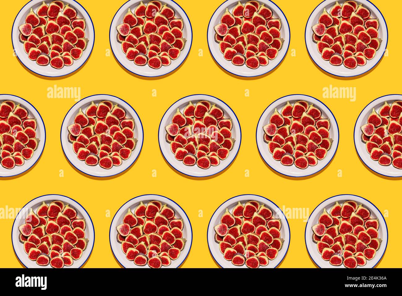 Pattern of plates with fresh halved figs Stock Photo