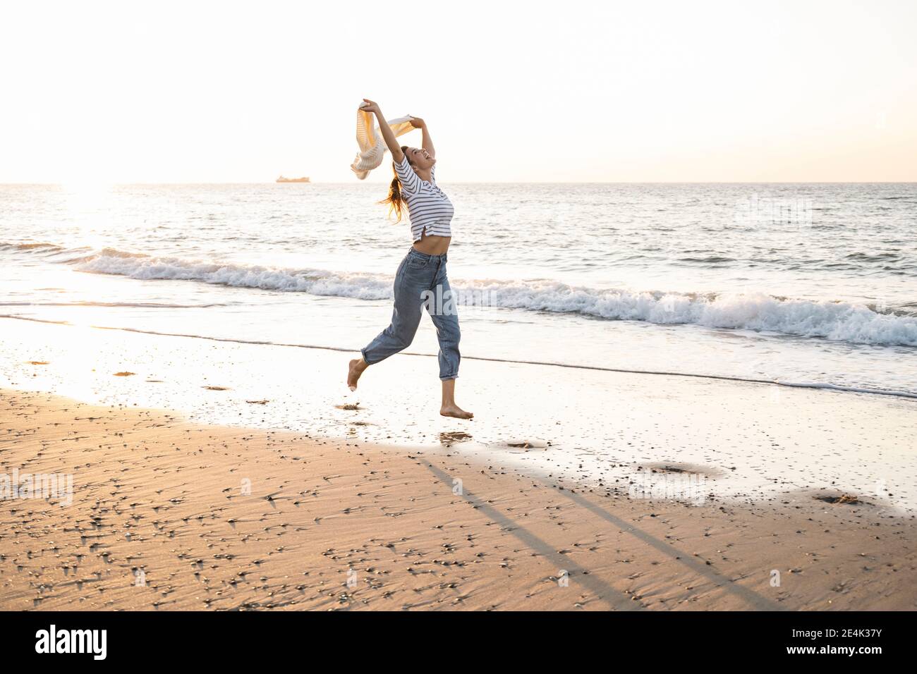 Woman sunset beach carefree hi-res stock photography and images - Alamy
