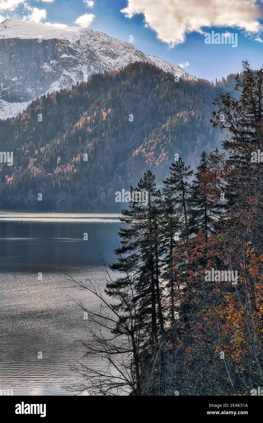 Lake Ritsa surrounded by forested mountains in autumn, Abkhazia, Georgia Stock Photo